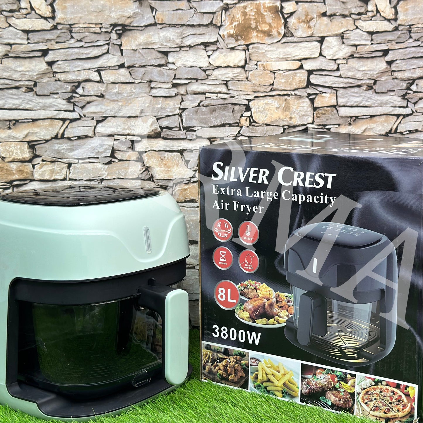 Silver Crest Air Fryer with a 8-liter capacity displayed alongside its packaging box. The appliance is green in color with a glass bowl visible and touch screen interface.