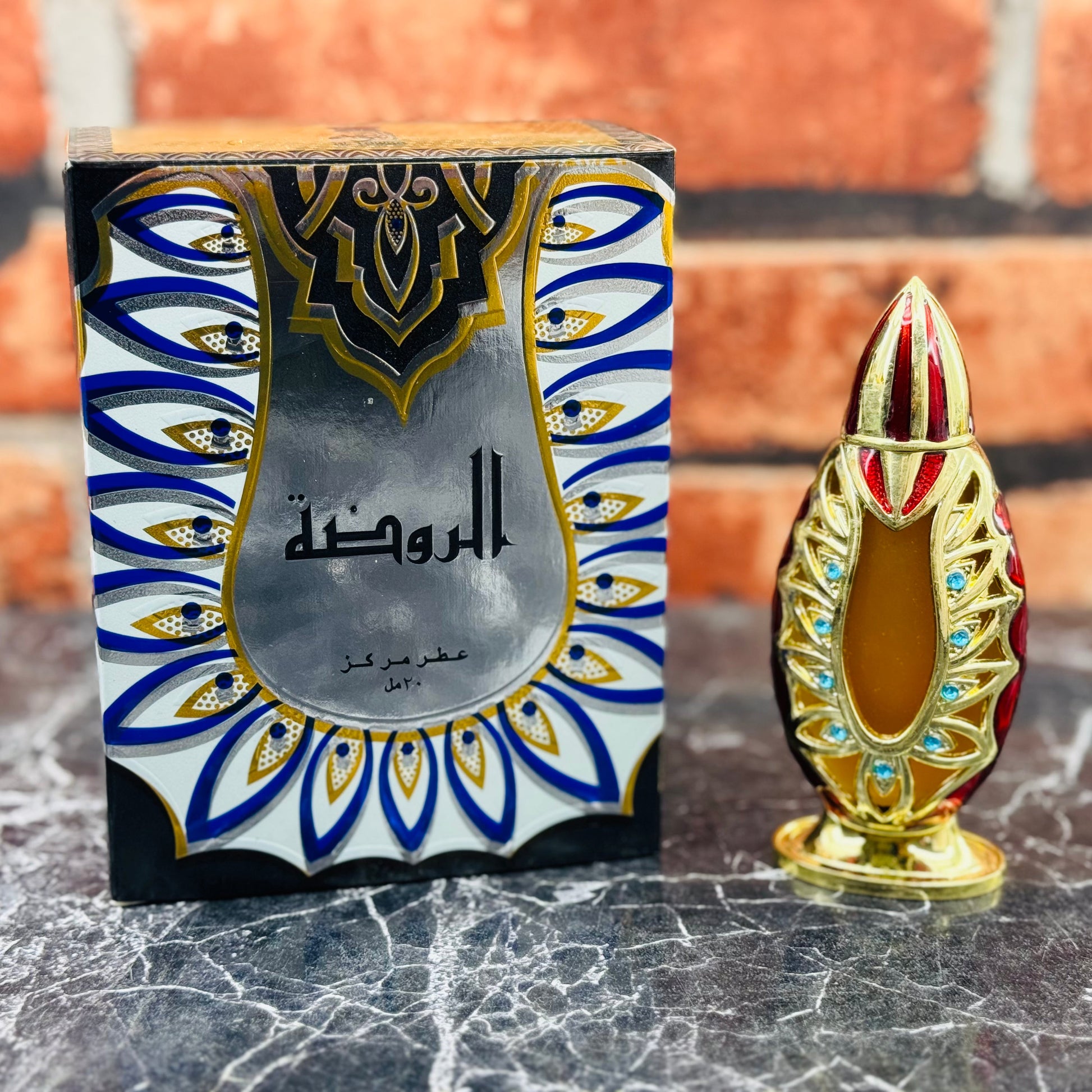 A perfume bottle with a decorative box, the bottle is tall and slender with a gold cap, and the box features intricate blue and gold designs.