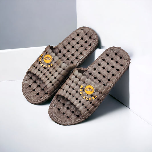 A pair of brown anti-slip slippers with a textured surface, placed on a light background.